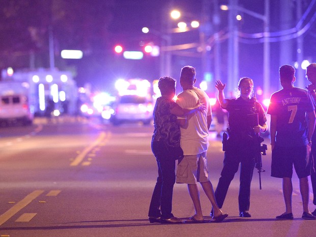 Policial orienta família a ficar longe da boate alvo do atirador em Orlando, nos Estados Unidos (Foto: Phelan M. Ebenhack/AP Photo)