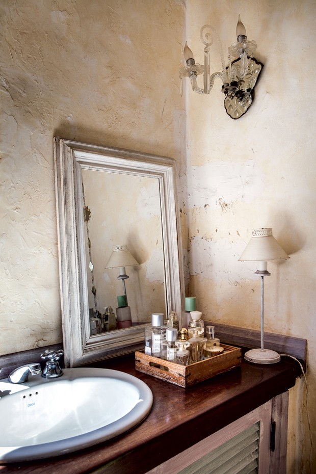 Lavabo | Bancada de madeira vinhático em tom mogno, espelho feito por artesão mineiro, e bandeja de pinho-de-riga do Antiquário A Estrela (Foto: Lufe Gomes)