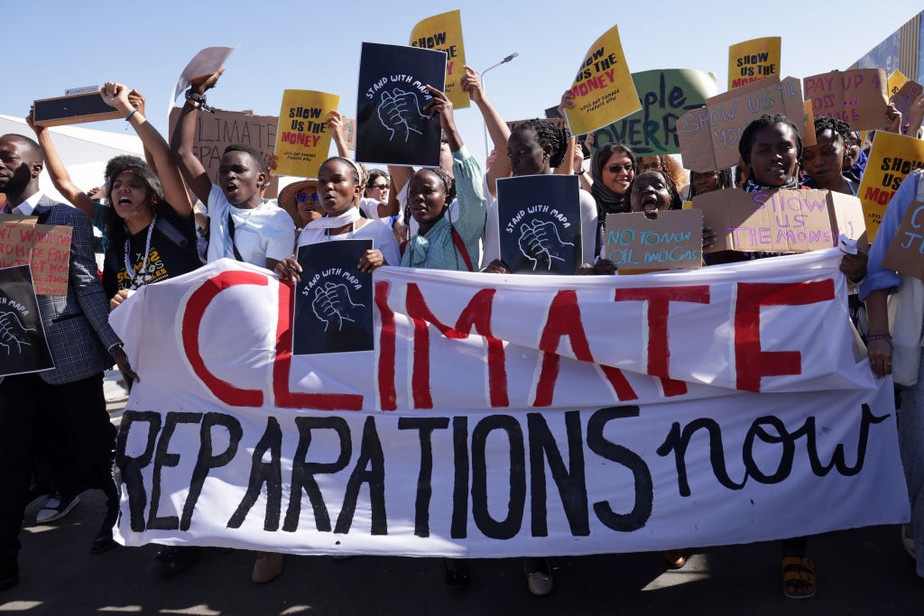 Jovens exigindo o pagamento de reparações climáticas de países ricos para países pobres afetados pelas perdas e danos climáticos marcham na COP27
