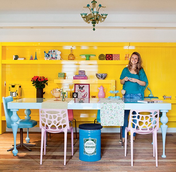 Cadeiras de diferentes modelos compõem a mesa de jantar azul-bebê. As peças também têm tons pastéis e contrastam com o amarelo vibrante da estante projetada pela arquiteta Letícia Arcangeli (Foto: Lufe Gomes/Casa e Jardim)