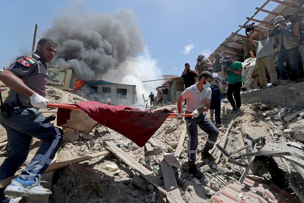 Palestinos tiram um corpo de escombros em Gaza, em 17 de maio de 2021 — Foto: Mohammed Salem/Reuters