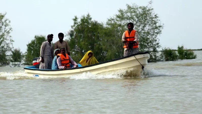 Pessoas fogem de enchentes no Paquistão (Foto: EPA via BBC)