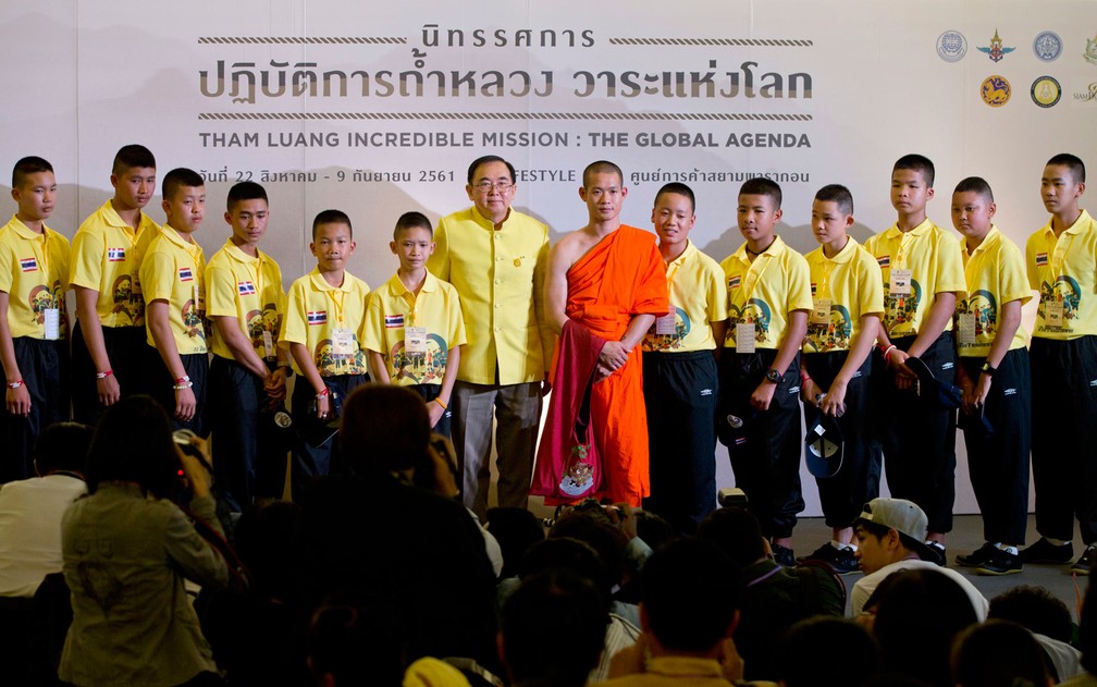 Os integrantes do ‘Javalis Selvagens’ e seu treinador posam para uma foto ao lado do ministro da Cultura da Tailândia, Veera Rojpojanarat, após palestra em Bangcoc, na quinta-feira (6) (Foto: AP Photo/Gemunu Amarasinghe)