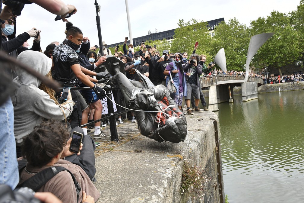 Manifestantes derrubam  estátua do traficante de escravos Edward Colston, em Bristol, na Inglaterra, no domingo (7) — Foto: Ben Birchall/PA via AP