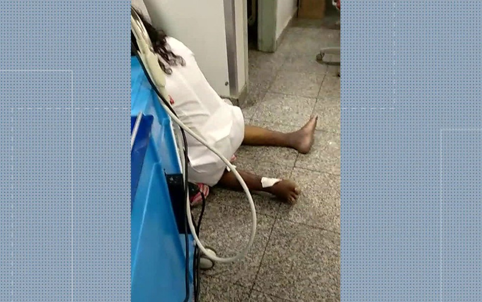Médicos fazem atendimento a paciente no chão do corredor de unidade municipal de saúde do Rio (Foto: Reprodução / TV Globo)