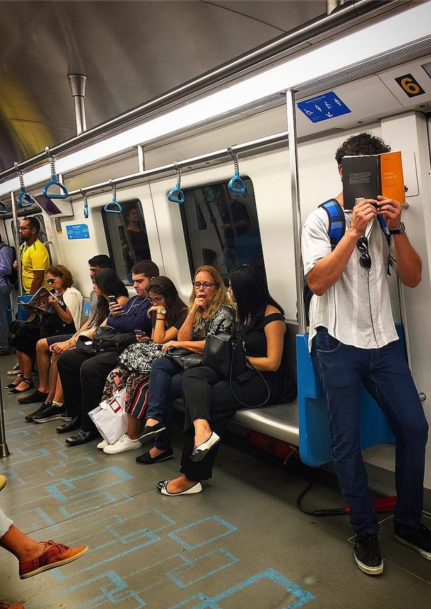 José Loreto se esconde atrás de livro para passar despercebido no metrõ (Foto: Reprodução/Instagram)