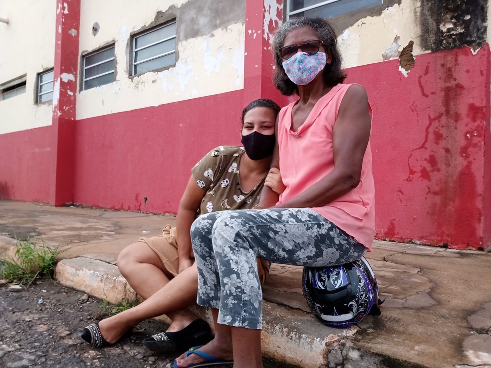 Evellyn e a bisavó Ana aguardando na "fila dos ossinhos" nesta quinta-feira (23) — Foto: Rogério Júnior/g1 MT
