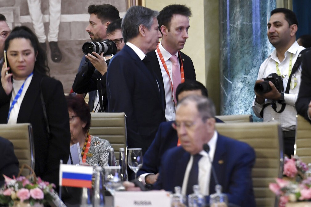 O secretário de Estado norte-americano, Antony Blinken (de pé, no centro), e o chanceler russo, Sergei Lavrov (sentado), durante reunião do G20 na Índia, em 2 de fevereiro de 2023. — Foto: Olivier Douliery/Pool via AP