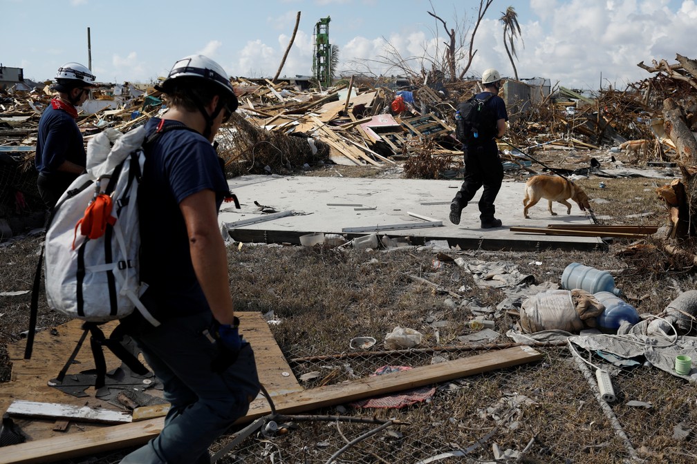 Equipe de bombeiros canadenses procura por corpos de vítimas do Dorian em Marsh Harbour, nas Bahamas, na terça-feira (10). — Foto: Marco Bello / Reuters