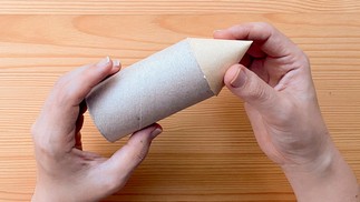 Passo 2: Enrole o papel formando um cone. Cole em uma das bordas do rolo de papel higiênico. — Foto: Tamy Rente