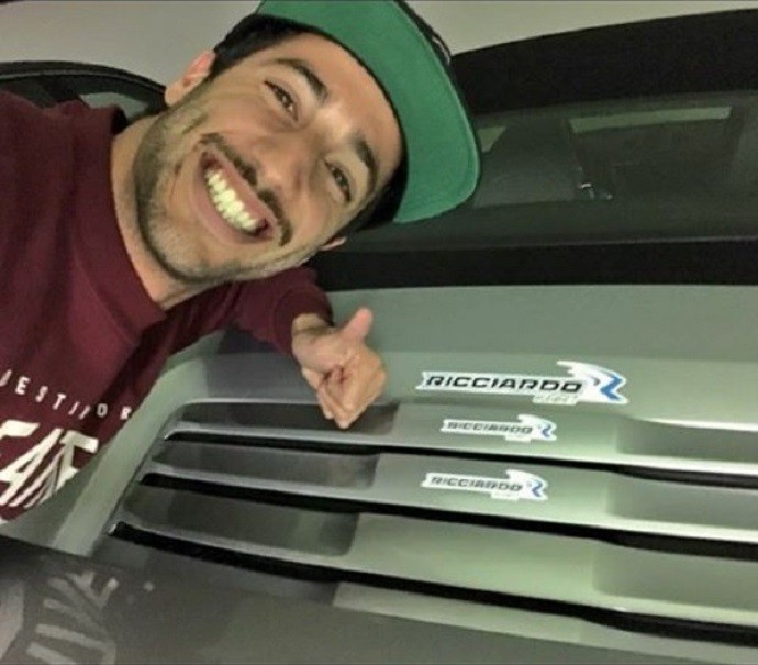 Daniel Ricciardo cola adesivos no carro de Felipe Massa (Foto: Reprodução)