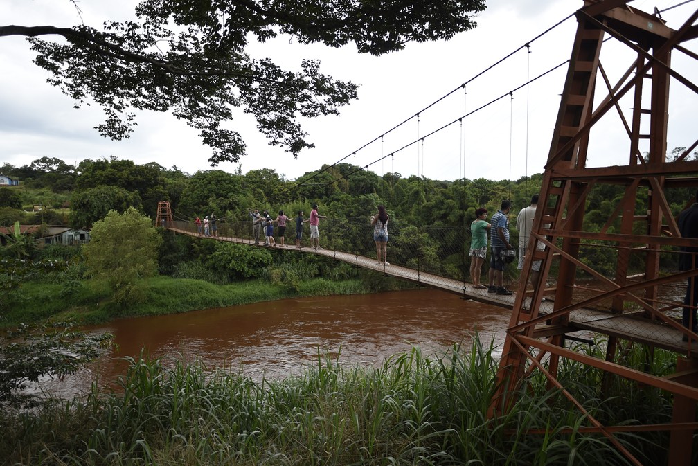 Pessoas olham para o rio Paraopeba, atingido pela lama depois do rompimento da barragem da Vale em Brumadinho. â€” Foto: Douglas Magno/AFP