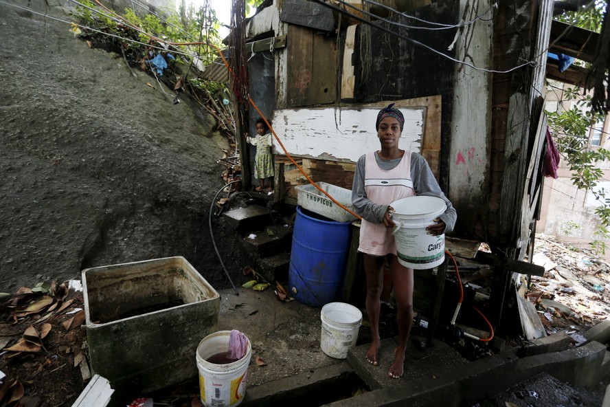Com 32 anos, Lanuzia Santana Villas Boas mora desde que nasceu no mesmo barraco de madeira, no Pavão-Pavãozinho, e nunca teve banheiro em casa: ela e os filhos pequenos usam penicos e tomam banho de balde