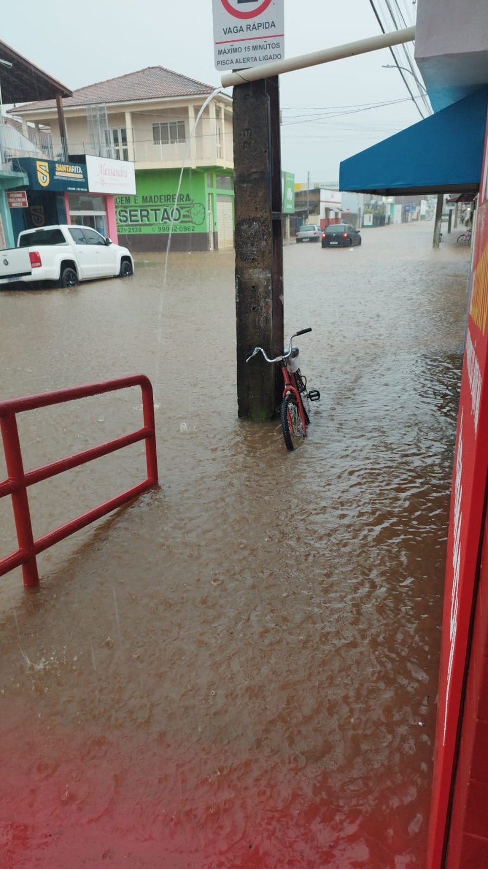 Chuva com granizo e vento deixa ruas alagadas e derruba telhado de lojas em Santa Rita do Sapucaí, MG — Foto: Reprodução