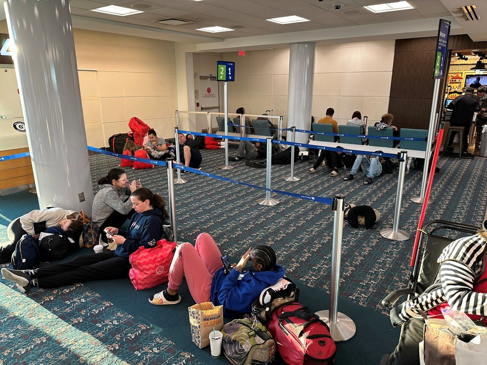 Passageiros esperam deitados no aeroporto internacional de Orlando após suspensão temporária de todos os voos nos EUA, em 11 de janeiro de 2023.  — Foto:  Lou Mongello/via Reuters