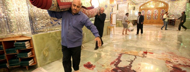 Trabalhadores limpam a cena após atentado que deixou pelo menos 15 pessoas mortas no mausoléu Shah Cheragh, na cidade iraniana de Shiraz — Foto: AFP