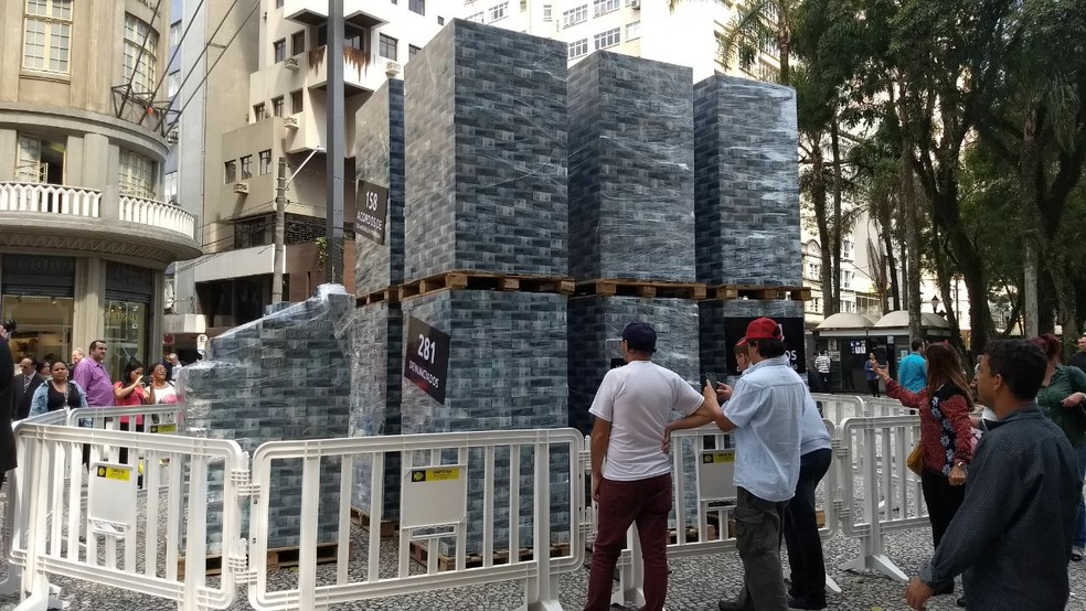 Na ação, cédulas falsas de dinheiro foram organizadas em uma estrutura montada na Rua XV de Novembro (Foto: João Salgado/RPC)