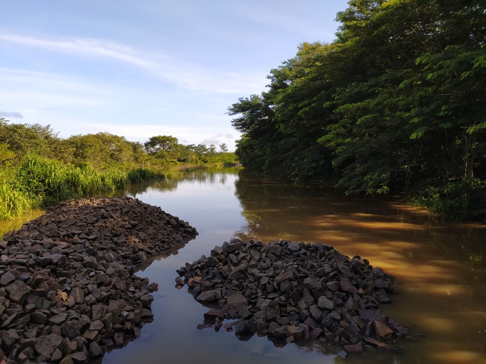 Dnit joga pedra na BR-364 para elevar pista e liberar o tráfego de veículos — Foto: Rinaldo Moreira