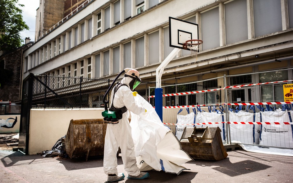 Funcionário participa de operação de descontaminação de chumbo na escola Saint Benoit, perto da Catedral de Notre-Dame, em Paris, no dia 8 de agosto — Foto: Martin Bureau/AFP