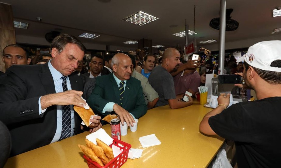 Jair Bolsonaro come pastel em feira em Brasília