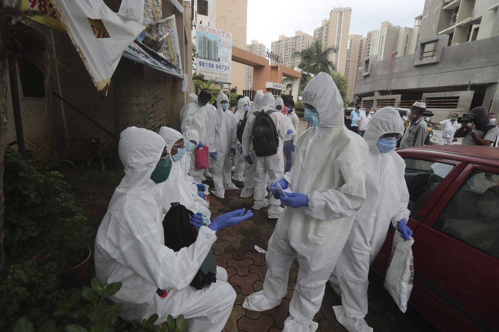 Trabalhadores da sa&uacute;de com roupas de prote&ccedil;&atilde;o em &aacute;rea residencial de Mumbai, na &Iacute;ndia, durante a pandemia do novo coronav&iacute;rus (COVID-19) &mdash; Foto: Rafiq Maqbool/AP
