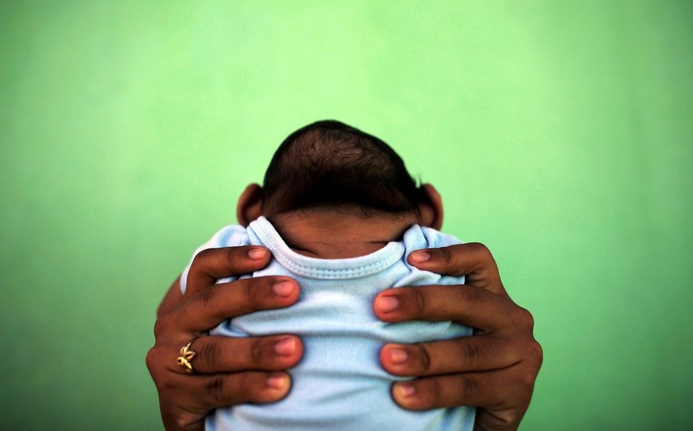 Jackeline Vieira de Souza,  então com 26 anos, segurando o filho de quatro meses Daniel, em Olinda, em 2016 — Foto: Ueslei Marcelino/Reuters