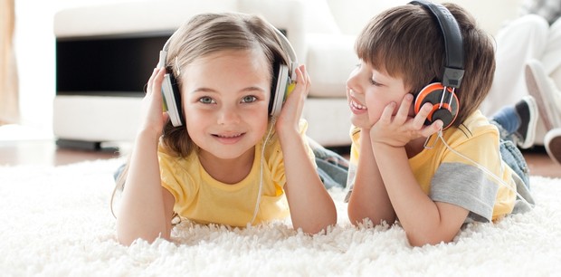 Crianças ouvindo música com fones de ouvido (Foto: Shutterstock)