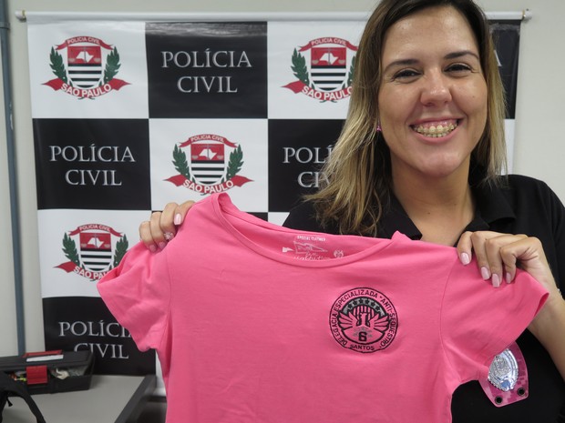 Katherine mostra a blusa rosa da polícia que ganhou dos colegas (Foto: Mariane Rossi/G1)