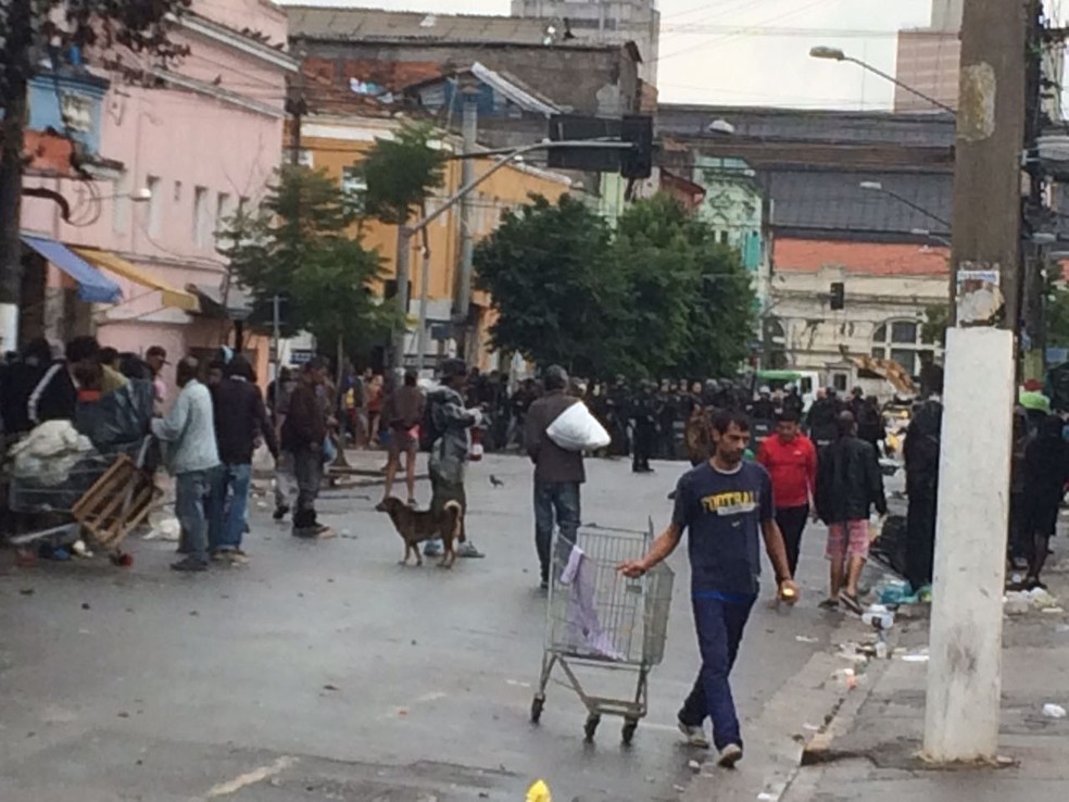 Pessoas retiram pertences da região e tropa de Choque da PM permanece fechando a rua (Foto: Paula Paiva/G1)