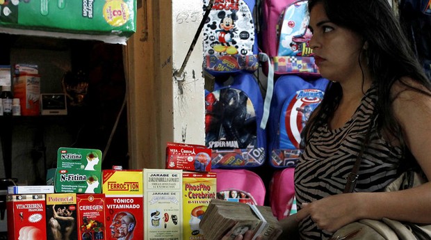 Mulher vai às compras com maço de cédulas: com hiperinflação, venezuelanos dependem de dinheiro em espécie  (Foto: Estadão Conteúdo)