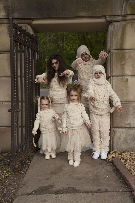 Uma Família Vestindo Uma Fantasia Branca De Halloween Enquanto Está De Pé  Na Sala · Foto profissional gratuita