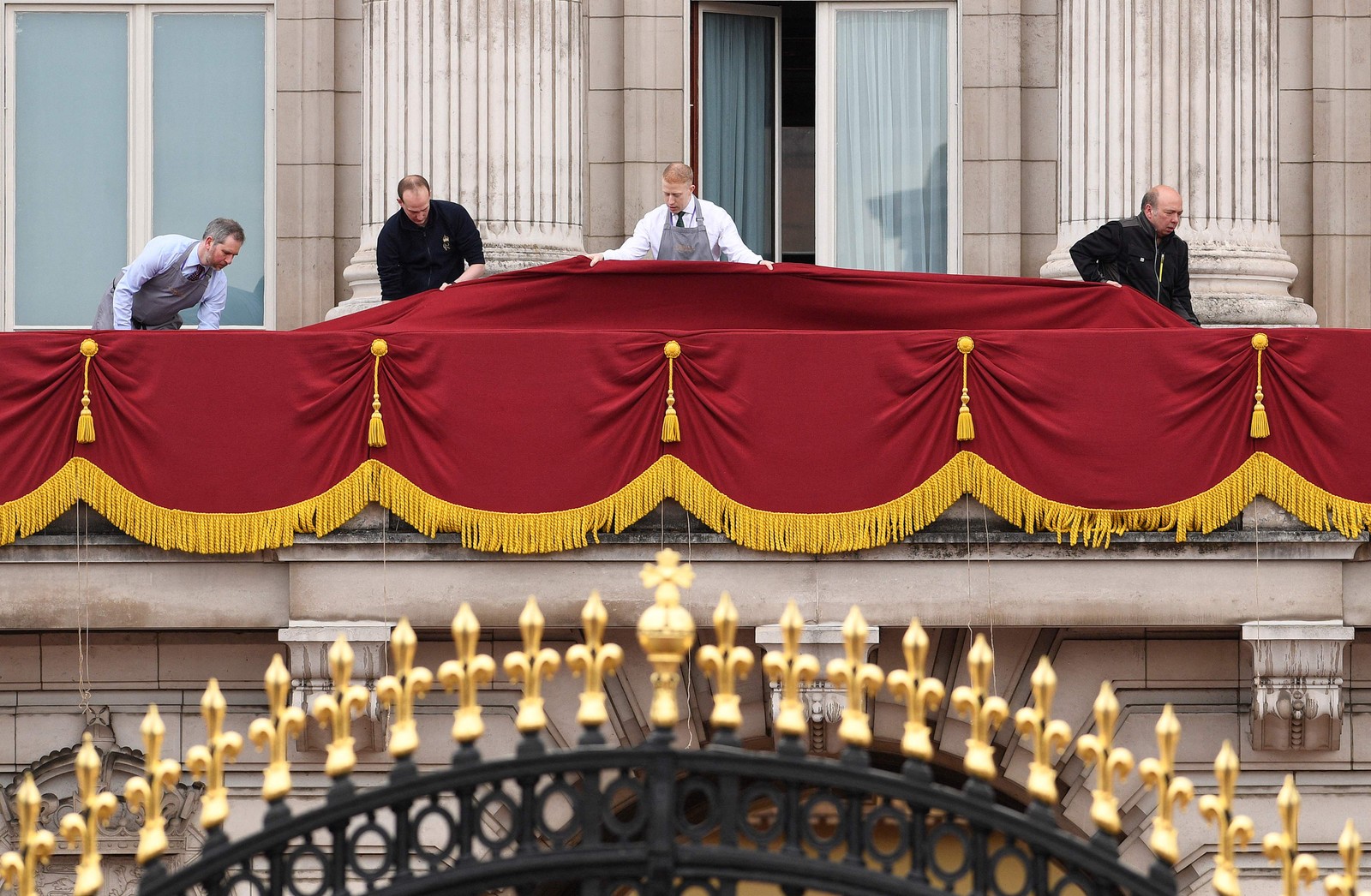 Trabalhadores fazem as últimas arrumações na varanda do Palácio de Buckingham, no centro de Londres, antes da cerimônia de coroação — Foto: Oli SCARFF / AFP