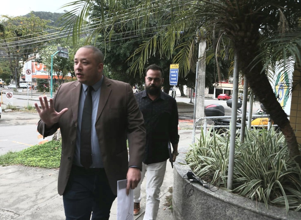 Médico Bruno Nogueira Teixeira chega à 16ª DP para depor acompanhado do advogado (de paletó) — Foto: Eliane Santos/g1 Rio 