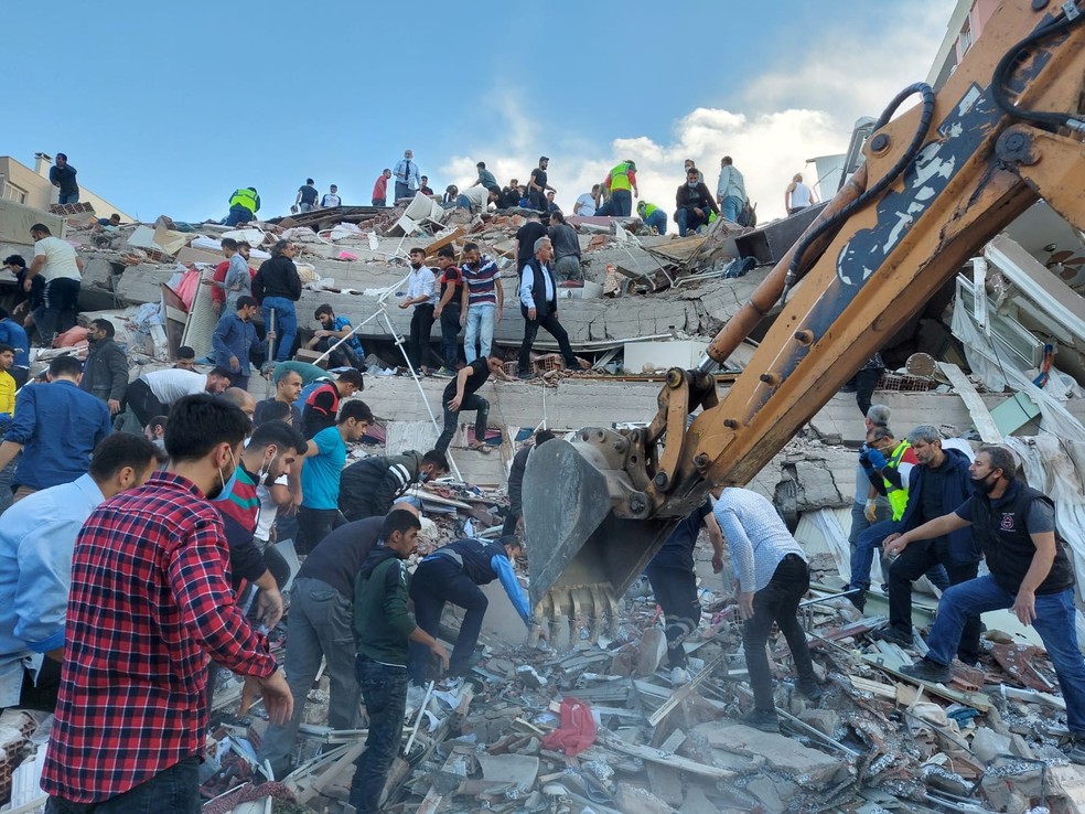 Escavadeira ajuda no trabalho dos socorristas para tentar buscar por sobreviventes em desabamento na Turquia após forte terremoto no Mar Egeu nesta sexta-feira (30) — Foto: Tuncay Dersinlioglu/Reuters