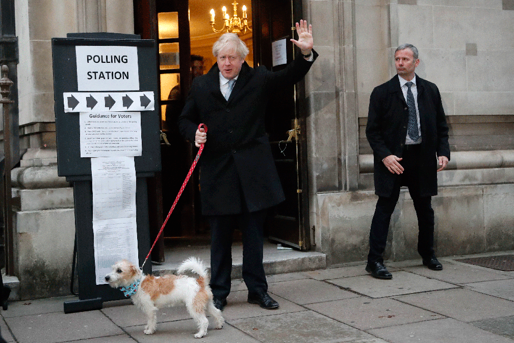 Premiê britânico, Boris Johnson, deixa seção onde votou em Londres nesta quinta-feira (12) com o seu cachorro, Dylan  — Foto: Frank Augstein/AP