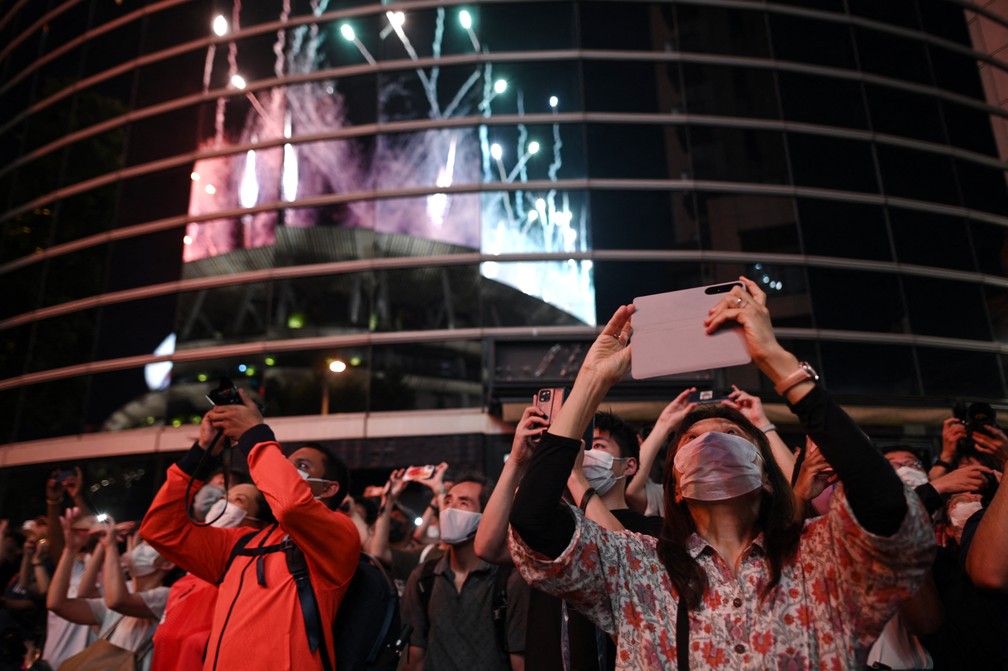 Público fora do Estádio Olímpico assiste aos fogos de artifício iluminarem o céu durante a cerimônia de encerramento dos Jogos Olímpicos de Tóquio — Foto: Yuki IWAMURA / AFP