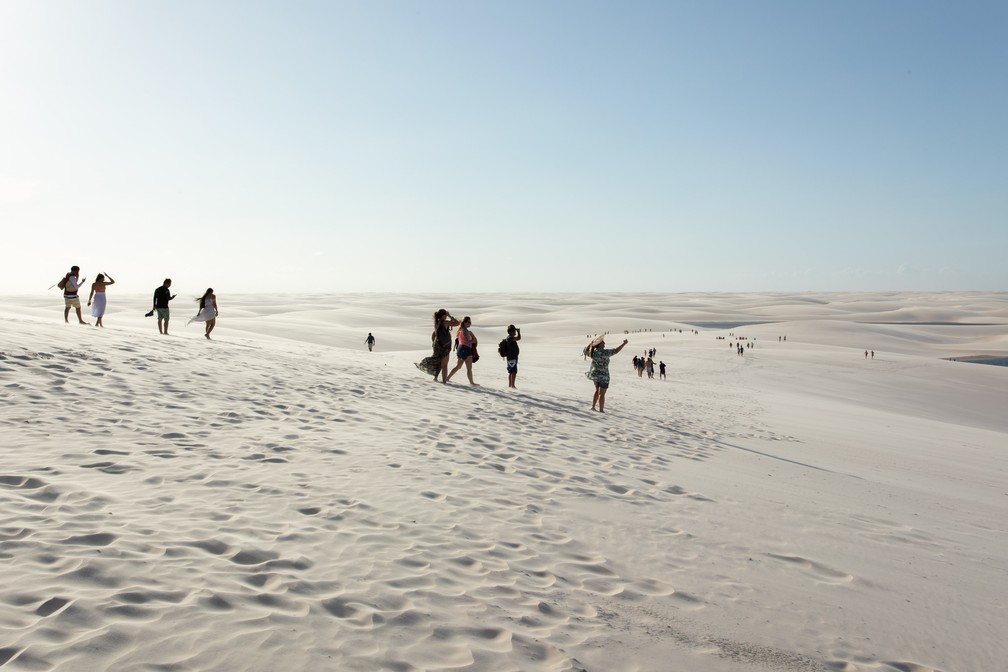 Turistas caminhando pelas dunas: próxima lagoa é objetivo a ser alcançado — Foto: Celso Tavares/G1