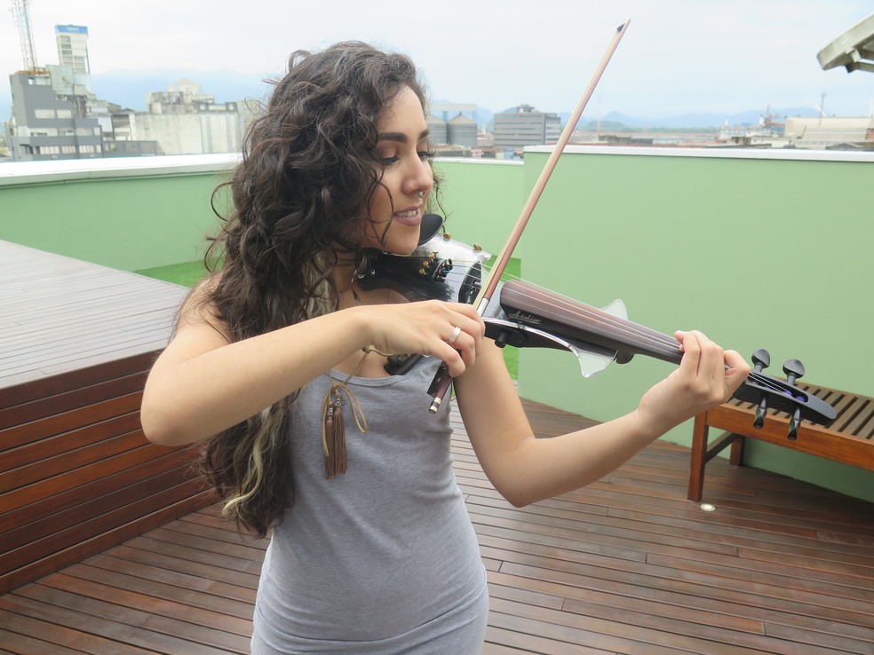 Lyarah faz sucesso tocando no violino músicas populares em Santos, SP. (Foto: Andressa Barboza/G1)