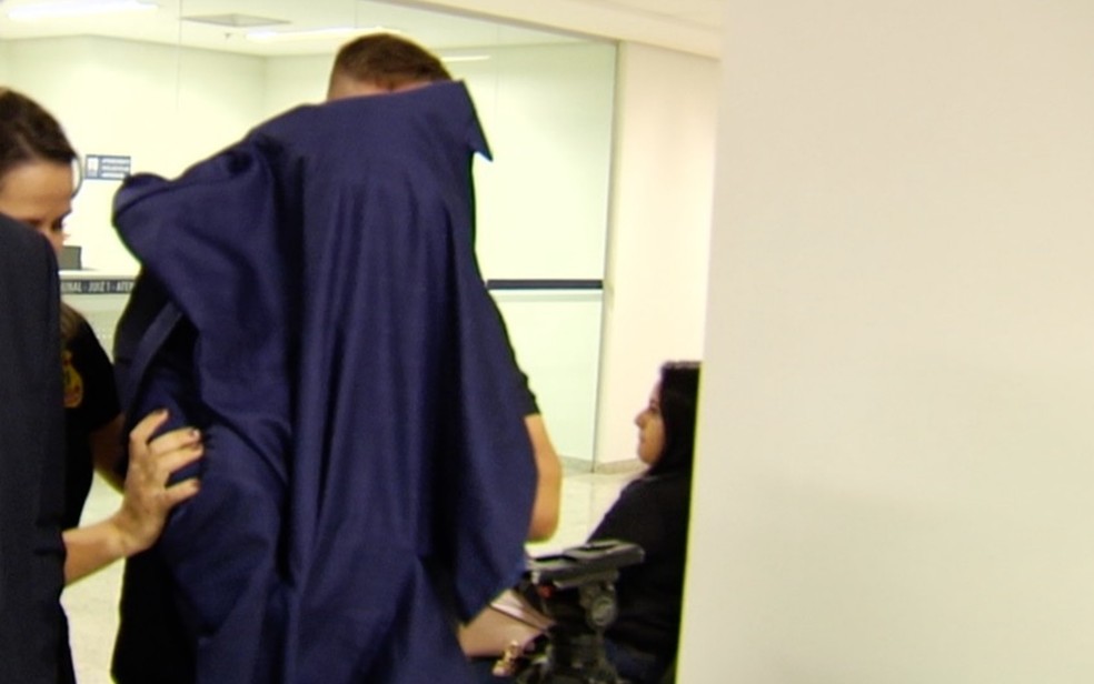 Médico preso por importunação sexual chegando para audiência de custódia Goiânia Goiás — Foto: Reprodução/TV Anhanguera