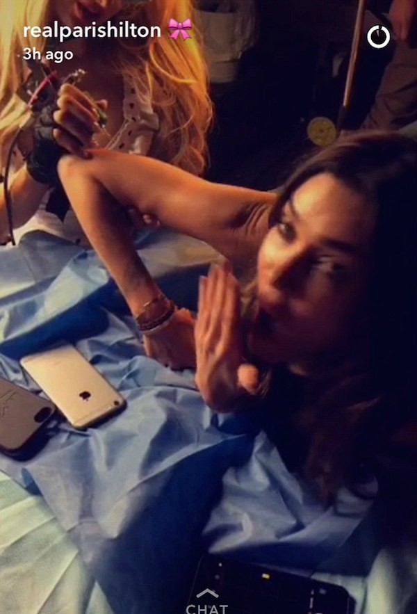 A celebridade Paris Hilton ajuda nos retoques finais da tatuagem da amiga (Foto: Snapchat)