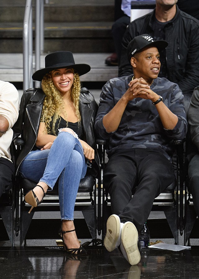 Beyoncé atrai os flashes (de jeans skinny e chapéu) para jogo de basquete (Foto: Getty Images)