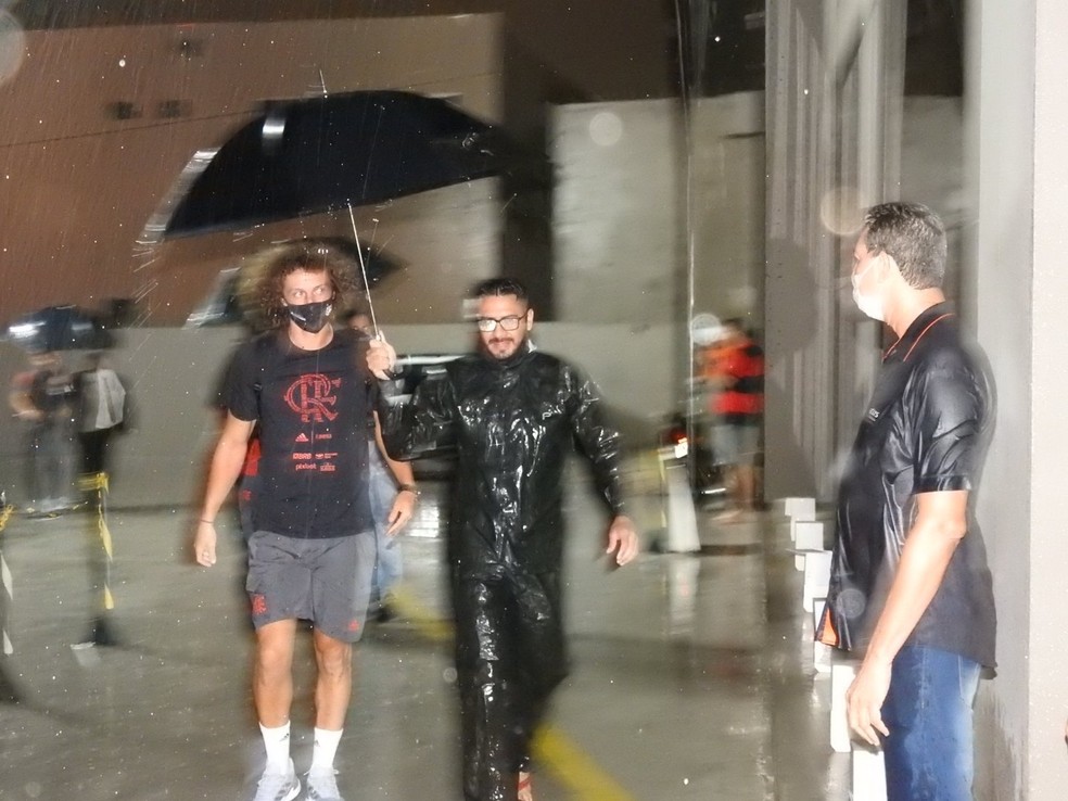 A foto deu uma tremida, mas &eacute; poss&iacute;vel ver o quanto chovia na chegada de David Luiz ao hotel &mdash; Foto: Fred Gomes