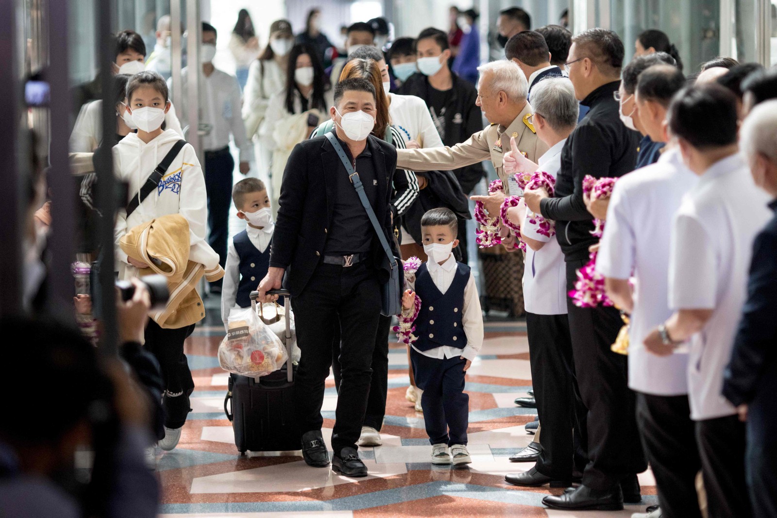 Viajantes de um voo da Xiamen Airlines são recebidos por autoridades de saúde tailandesas e do governo ao chegarem ao aeroporto de Suvarnabhumi, em Bangcoc, após a China remover as restrições de viagem da Covid-19. — Foto: Jack TAYLOR / AFP