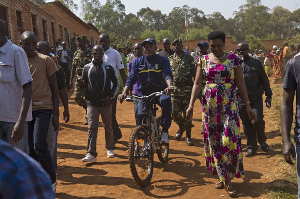 O presidente do Burundi, Pierre Nkurunziza, chega de bicicleta para votar em eleições presidenciais (Foto: Phil Moore/AP)