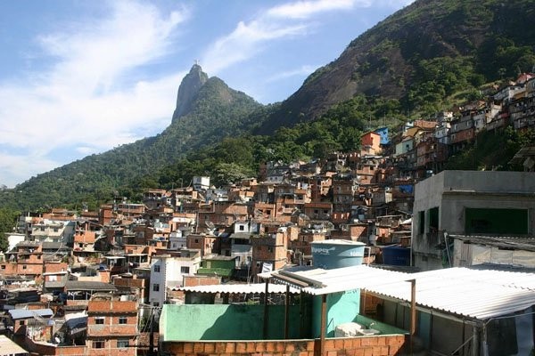 Realidade conhecida dos brasileiros, mas ignorada por muitos estrangeiros, o Cristo Redentor divide espaço com muitas comunidades nos morros cariocas (Foto: Reprodução)