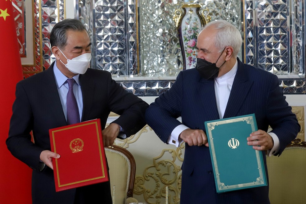 O ministro das Relações Exteriores do Irã, Mohammad Javad Zarif, e o ministro das Relações Exteriores da China, Wang Yi, acotovelam-se durante a cerimônia de assinatura de um acordo de cooperação de 25 anos, em Teerã, Irã, em 27 de março de 2021. — Foto: Majid Asgaripour/Wana via Reuters