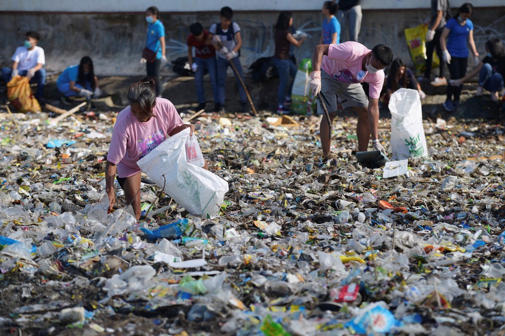 Imagem de setembro de 2018 mostra voluntÃ¡rios recolhendo plÃ¡stico da BaÃ­a de Manila â€” Foto: REUTERS/Eloisa Lopez