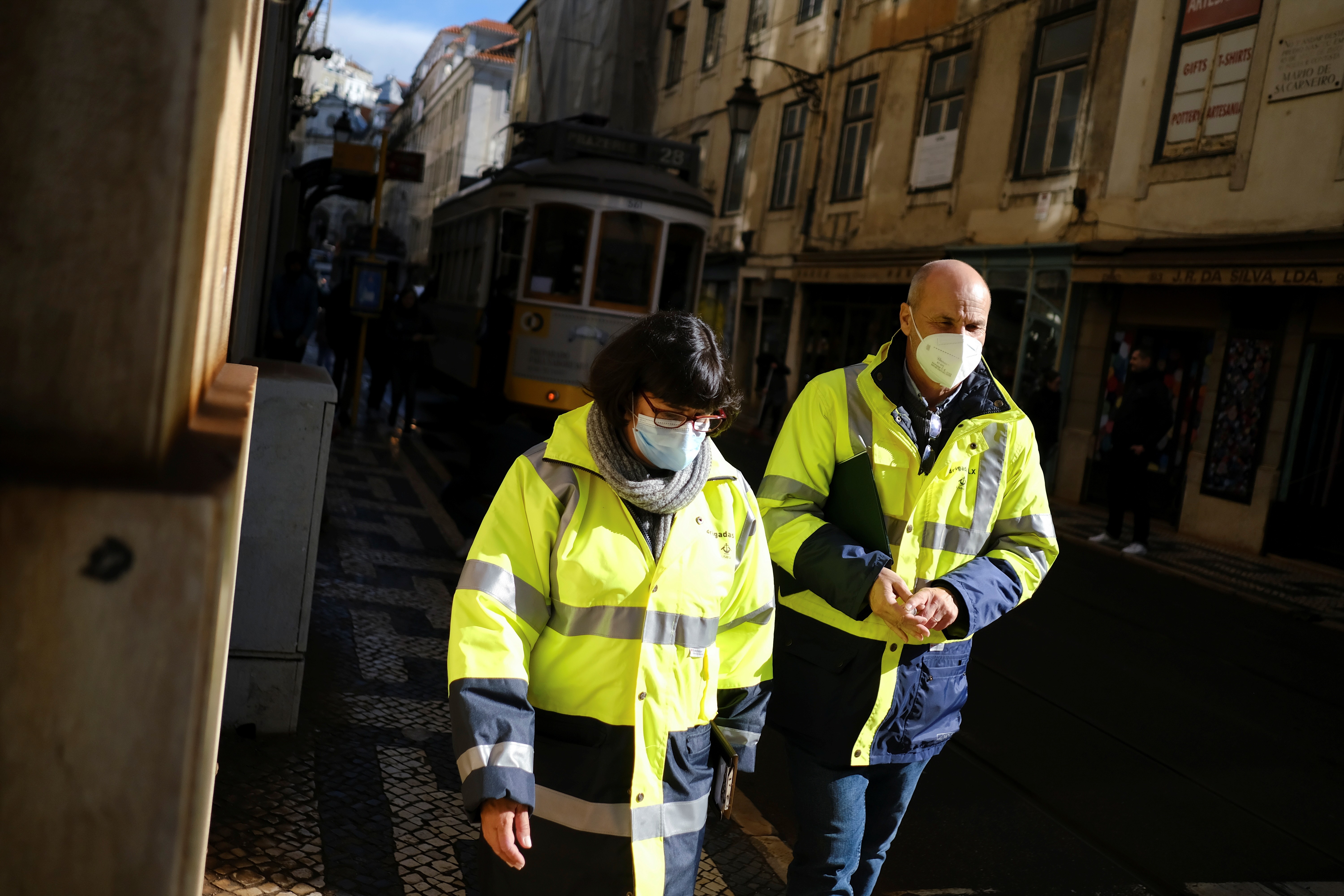 Pedestres usam máscaras em uma calçada no centro de Lisboa