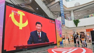 Pessoas assistem a uma transmissão ao vivo do presidente da China, Xi Jinping, falando durante a introdução do Comitê Permanente do Partido Comunista da China no Politburo — Foto: AFP