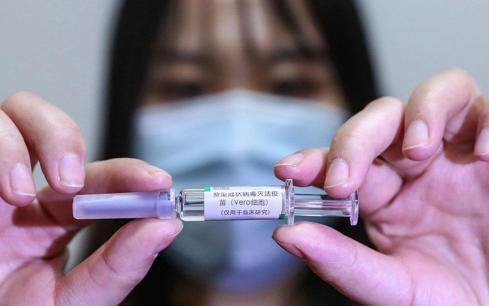 Funcionária exibe amostra de possível vacina contra a Covid-19 em Pequim, na China. — Foto: Zhang Yuwei/Xinhua via AP